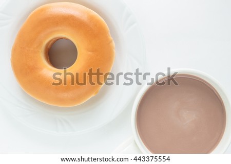 donut on white plate and cup cocoa drink top view on white background.