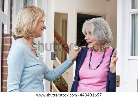 Woman Checking On Elderly Female Neighbor Royalty-Free Stock Photo #443401657