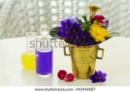 Flowers, brass mortar and bottles of potions, herbal medicine
