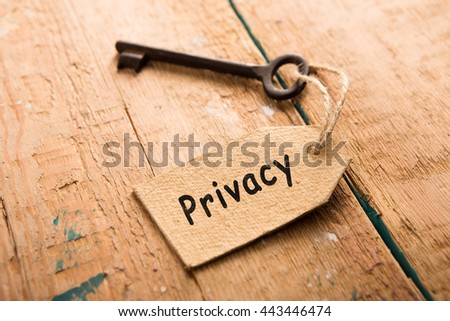 privacy concept - vintage key with tag with inscription on the wooden desk