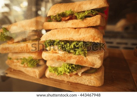 Toned picture of fresh sandwiches closeup with vegetables and meat fish represented in cafe or restaurant.