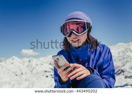 Skier woman look up in smart phone