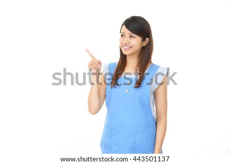 Smiling Asian housewife pointing