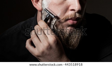
close-up of a man with a long beard and a mustache , beard shaves with a straight razor Royalty-Free Stock Photo #443518918