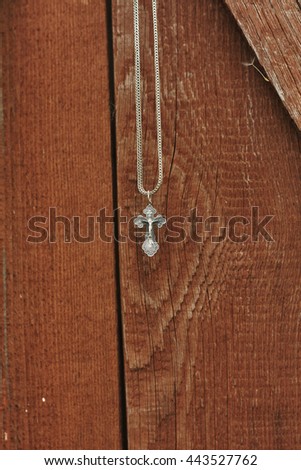 orthodox silver cross on chain on red backround 