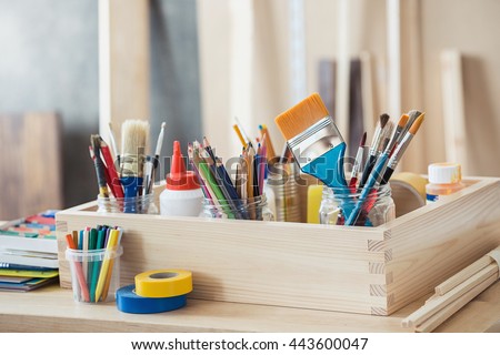 Paint brushes and crafting supplies on the table in a workshop. Royalty-Free Stock Photo #443600047
