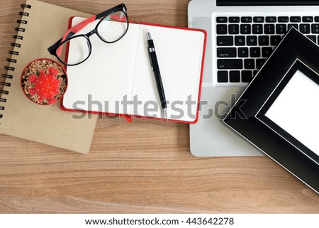 Work desk with laptop, glasses, notebook and pencil
