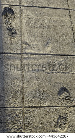 Two footprints in the cement sidewalk