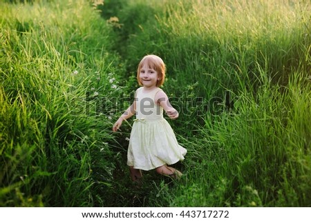 Outdoor portrait of a cute little girl playing in the grass, childhood, happiness, nature, relaxation