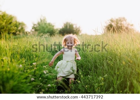 Outdoor portrait of a cute little girl playing in the grass, childhood, happiness, nature, relaxation