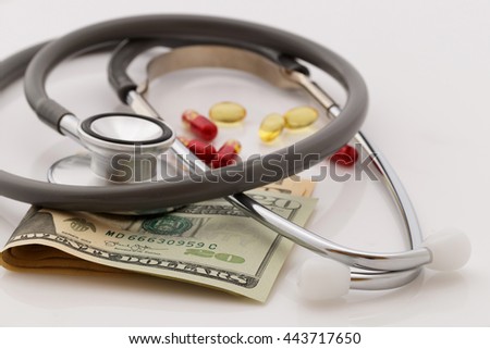 Stethoscope, dollars money and mixed medicine on white background.Selective focus.Medical business concept.