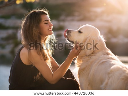 Beauty woman with her dog playing outdoors Royalty-Free Stock Photo #443728036