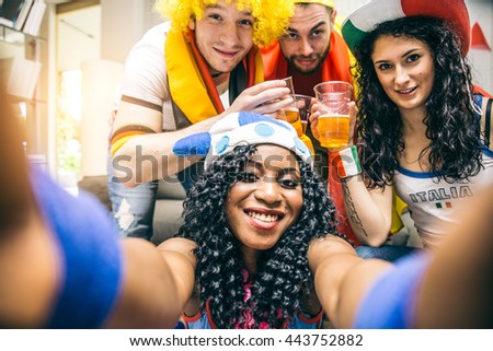 Group of sport supporters taking a selfie at a home party - Friends celebrating during a football match at home