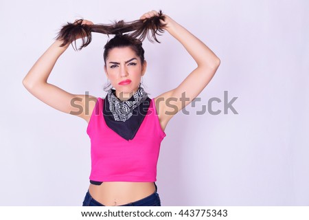 Portrait of fashionable young woman wearing stylish urban clothes. Fashion studio portrait over grey backgroung.