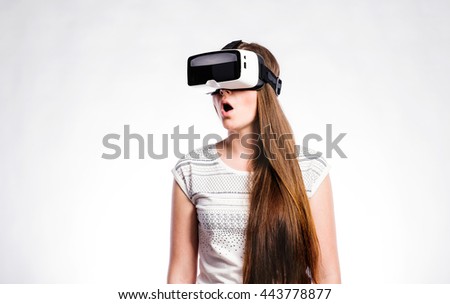 Woman with virtual reality goggles. Studio shot, gray background