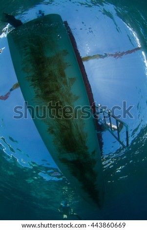 Jukung, traditional indonesian boat, a view from the bottom. Underwater view while diving, with a reflection of sky.