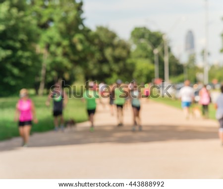 Defocused, blurred motion background of summer activities with energetic people jogging, walking, running and bicycling at green city park. Urban outdoor workout and sport. Healthy lifestyle concept.