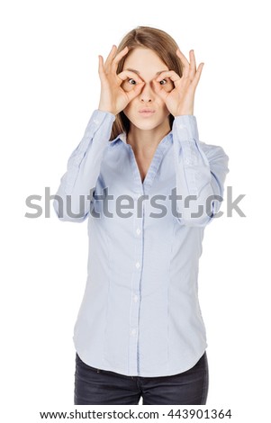 Portrait of young woman holding fingers like glasses. human emotion expression and lifestyle concept. image on a white studio background.