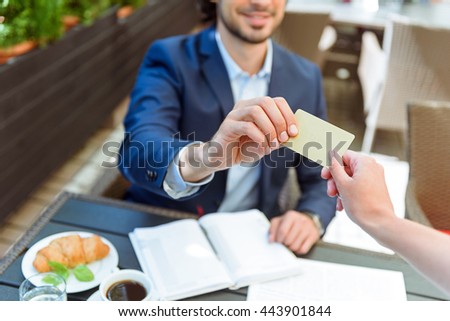 Successful businessman paying bill in cafe