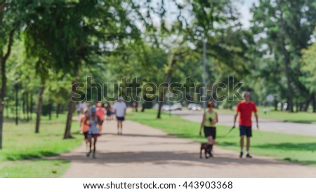 Defocused, blurred motion background of summer activities with energetic people jogging, walking, running and bicycling at green city park. Urban outdoor workout. Healthy lifestyle concept. Panorama.