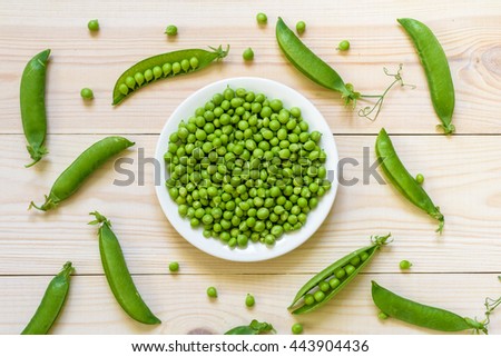Green pea in bowl of top view on rustic wooden background with copy space, natural wooden table. Flat lay.  Royalty-Free Stock Photo #443904436