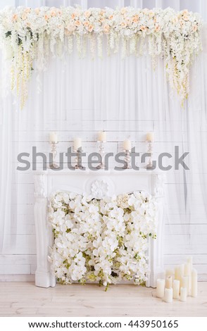 Elegant white fireplace full of flowers instead of fire and beautiful flower composition above it. Wedding ceremony & Wedding decorations