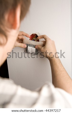 Picture of a man installing a switcher into the wall