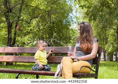 Little boy sitting with his mother on bench