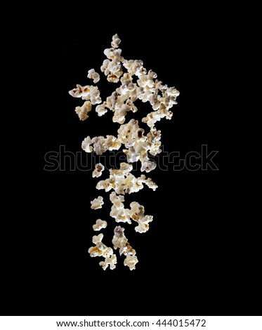 popcorn bursting in the air over black background