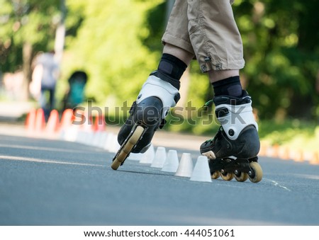 Man roller skating with cups on road in park