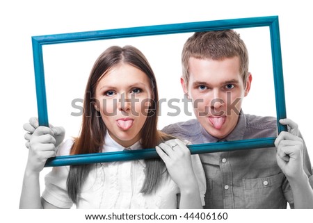 Couple with stick out tongues look from picture frame