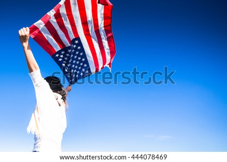 Young woman proudly waving the American flag at sunrise, American Celebration