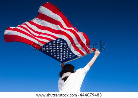 Young woman proudly waving the American flag at sunrise, American Celebration