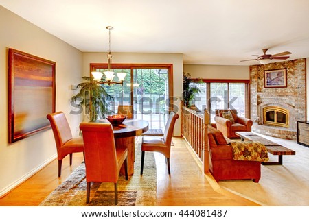 House with open floor plan. View of dining area with table set and brick fireplace in the living room.