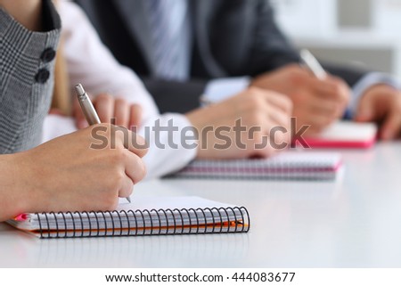 Close up view of students or businesspeople hands writing something during conference. Business meeting, blogging or professional education concept