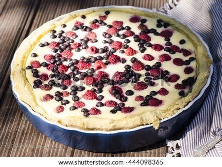 Sunny Photo with a morning breakfast in a rustic style. Cheesecake with raspberries and blueberries on wooden table. Selective focus picture
