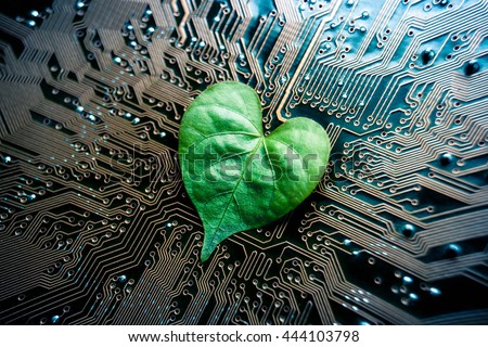 A green leaf with a heart shape on a computer circuit board / green it / green computing / csr / it ethics Royalty-Free Stock Photo #444103798
