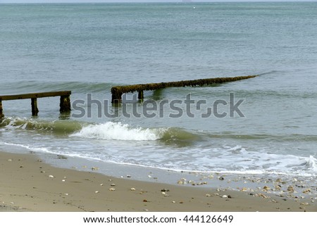 Waves rolling onto the beach through a groyne wave breaker.