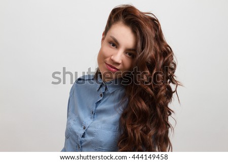 Brunette in denim shirt, isolated on gray background