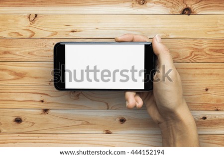 Girl using smartphone on wood table. 