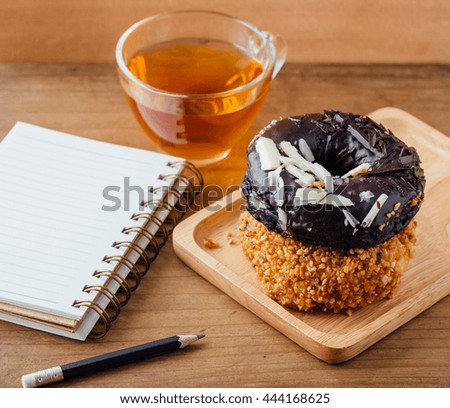 donuts with note book on wooden background