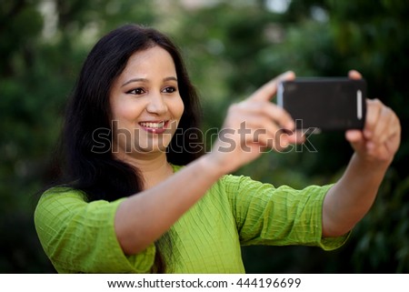Happy young woman taking selfie at outdoors