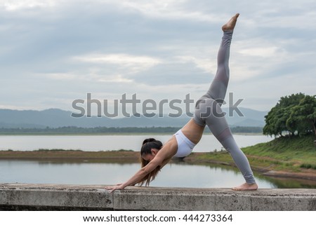 Young woman doing yoga exercise in beautiful mountain and lake background 