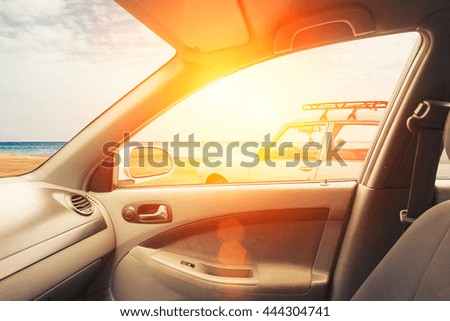 Interior of car with open window and beach on side