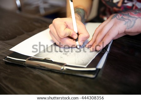 Male hand painting picture in notebook