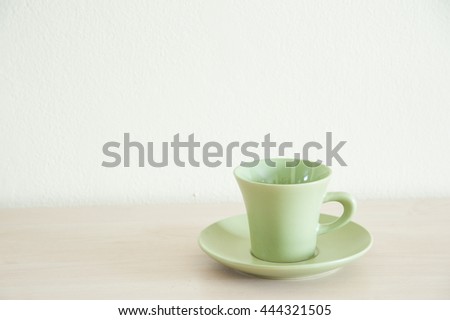Green coffee cup for take a break on the wooden table.