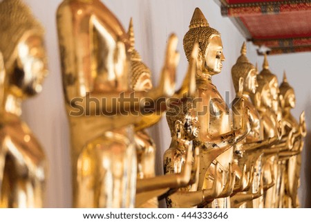 Row of golden buddha statues in Thailand.