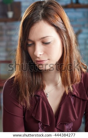 Portrait of thoughtful young woman looking down.