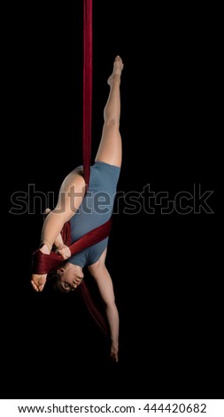 Graceful aerial dancer woman doing her performance isolated on black