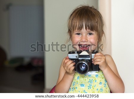 Cute little happy girl with vintage photo camera